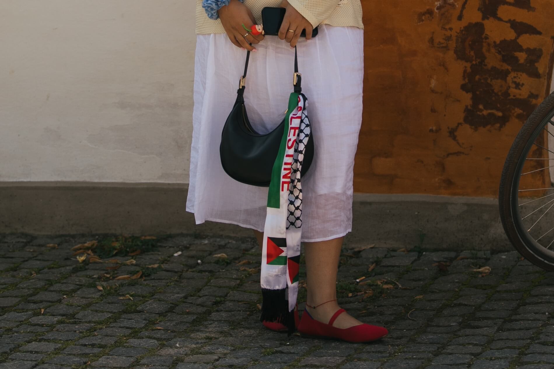 Žena s šátkem uvázaným na kabelce