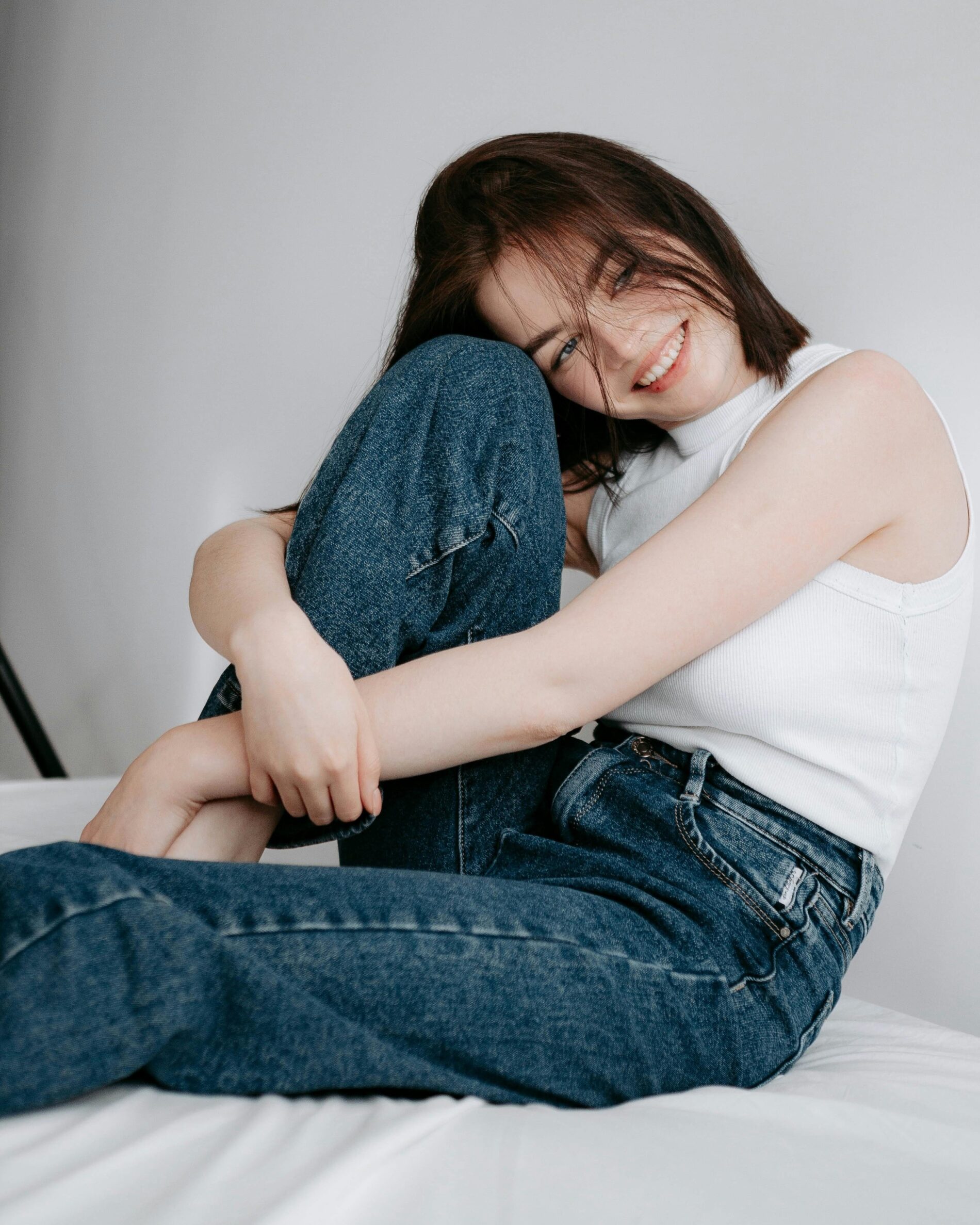 Žena oblečená v tílku a džínách